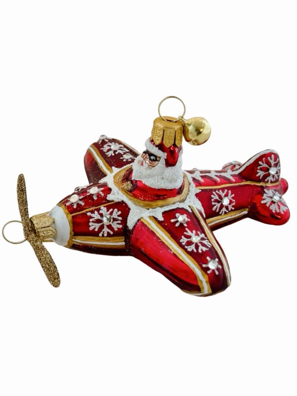 Festive Santa airplane Christmas ornament – a red and gold hand blown glass Christmas tree decoration featuring Santa Claus piloting a glittery holiday propeller plane adorned with snowflakes and snowy sparkling accents.