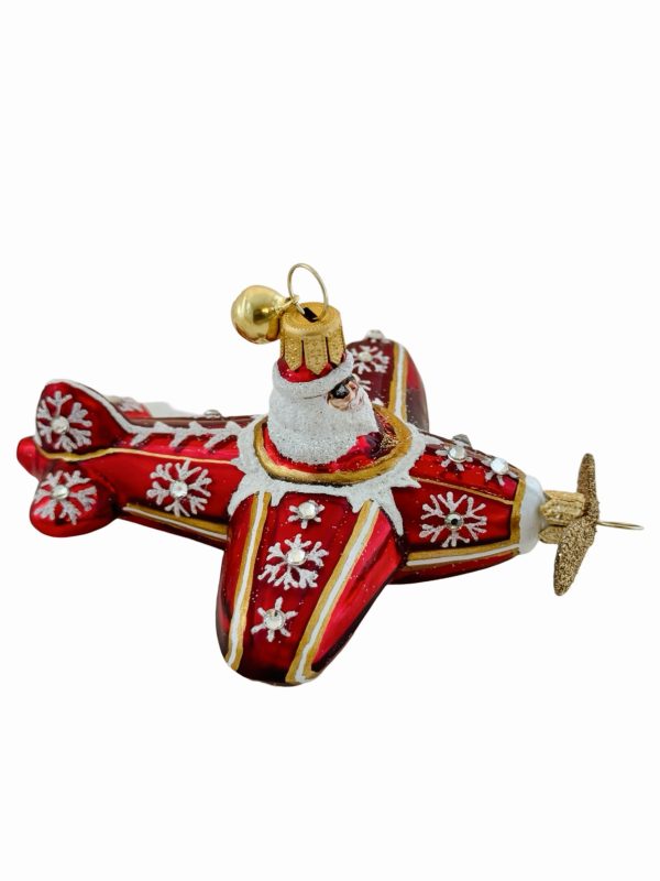 Festive Santa airplane Christmas ornament – a red and gold hand blown glass Christmas tree decoration featuring Santa Claus piloting a glittery holiday propeller plane adorned with snowflakes and snowy sparkling accents.