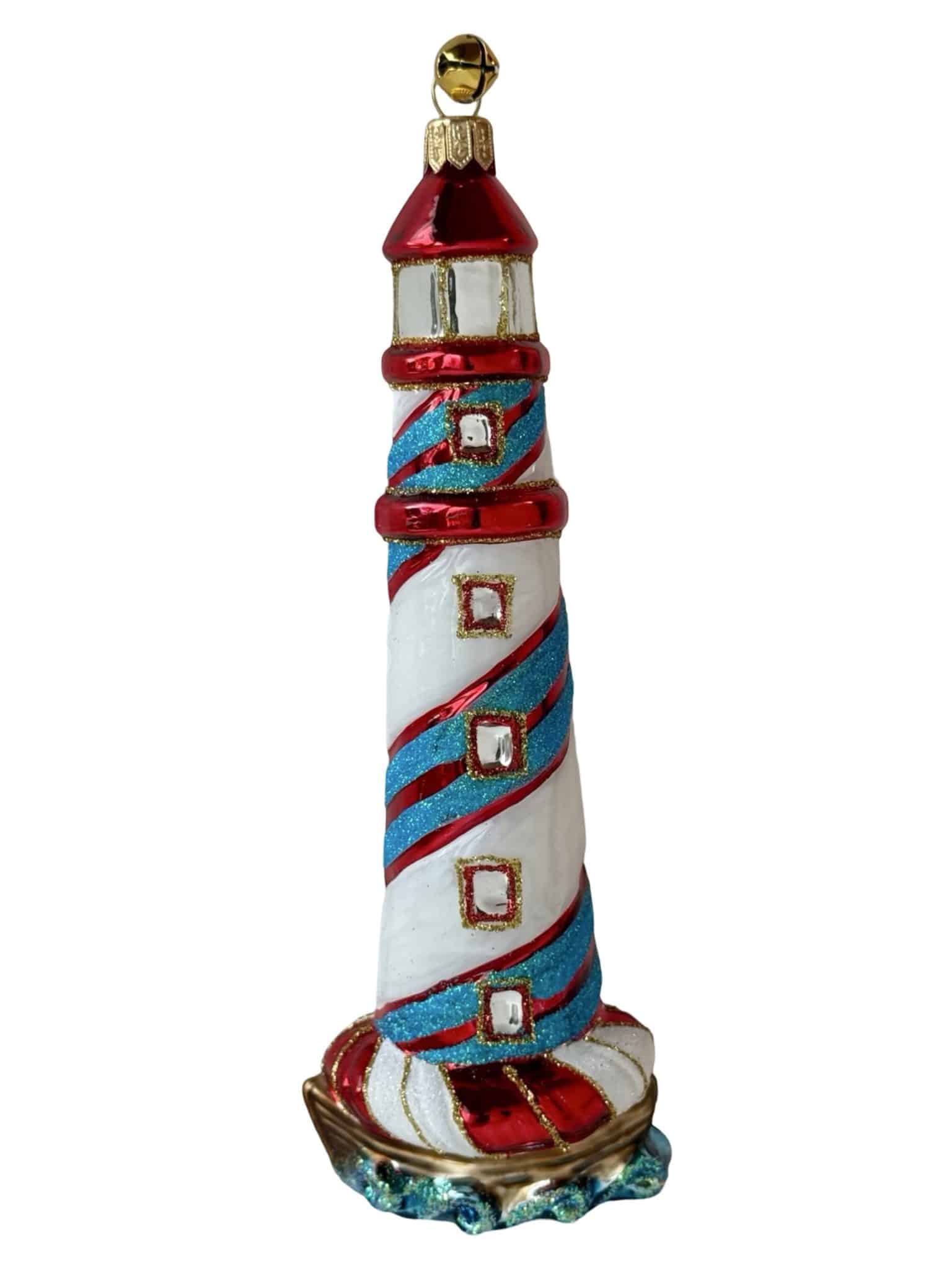 Glass lighthouse Christmas ornament with red, white, and blue stripes in a coastal nautical style